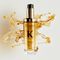 The new refillable Elixir Ultime is surrounded by beautiful golden hair oil drops and texture.